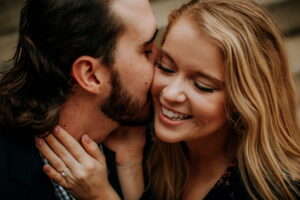 man kissing woman's cheek sweetly